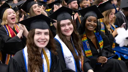 Students at commencement, smiling